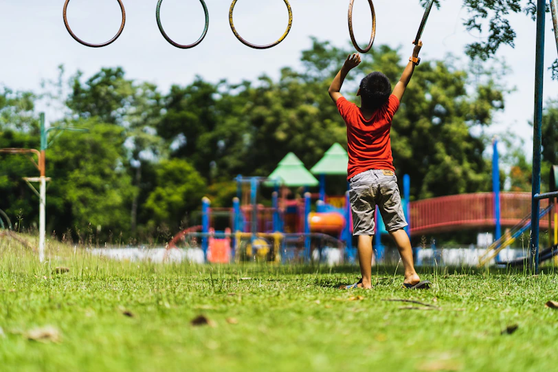 boy in red t-shirt and blue shorts playing basketball during daytime