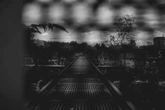 Dark moody photo of a winding labyrinth path beneath a cloudy night sky.