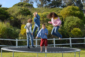 A family enjoying their in-ground trampoline in the backyard.