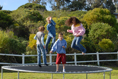 A family enjoying their in-ground trampoline in the backyard.