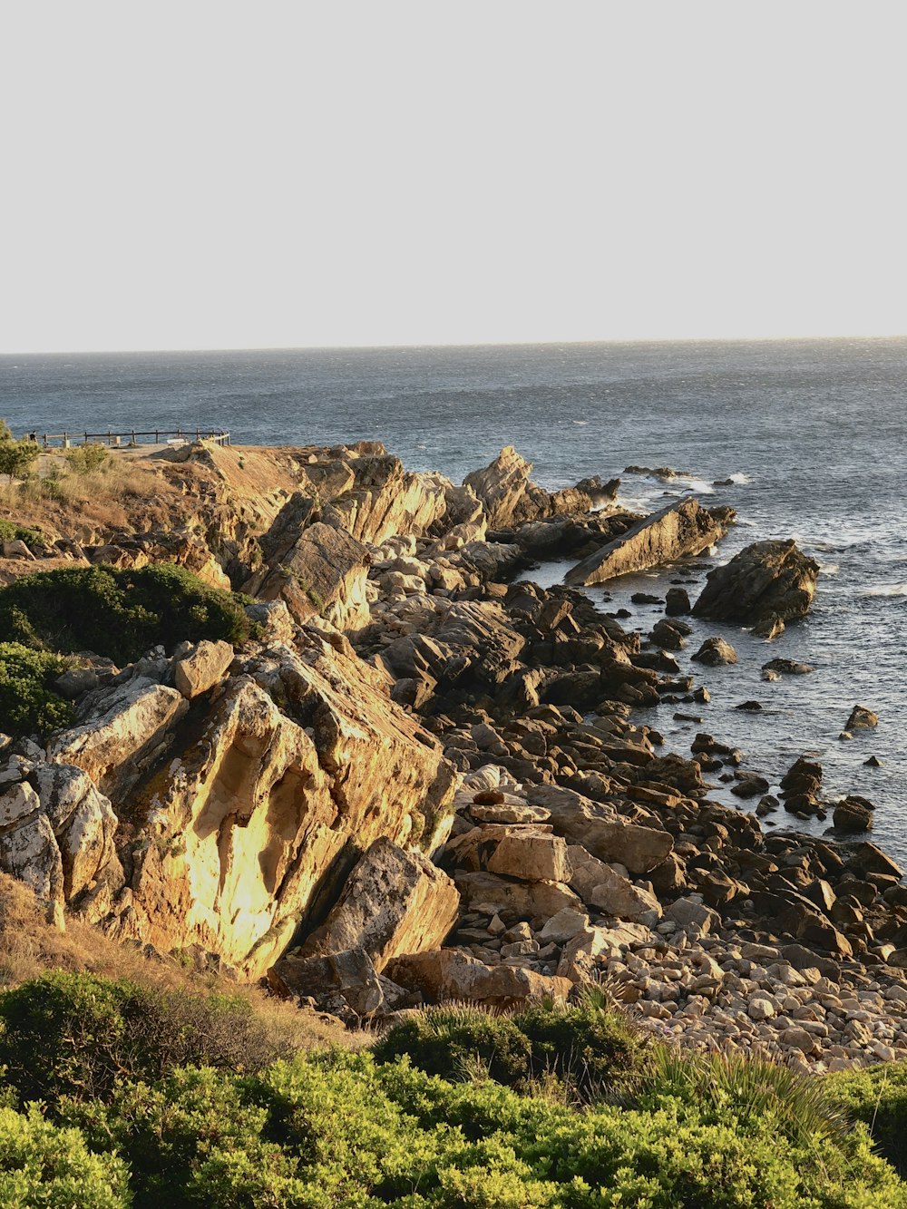 brown rock formation beside body of water during daytime