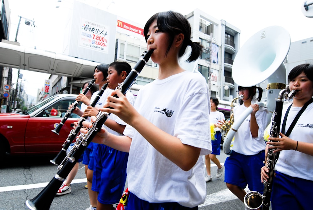 Mujer con camiseta blanca de cuello redondo sosteniendo un instrumento musical