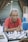 man in orange polo shirt sitting by the table
