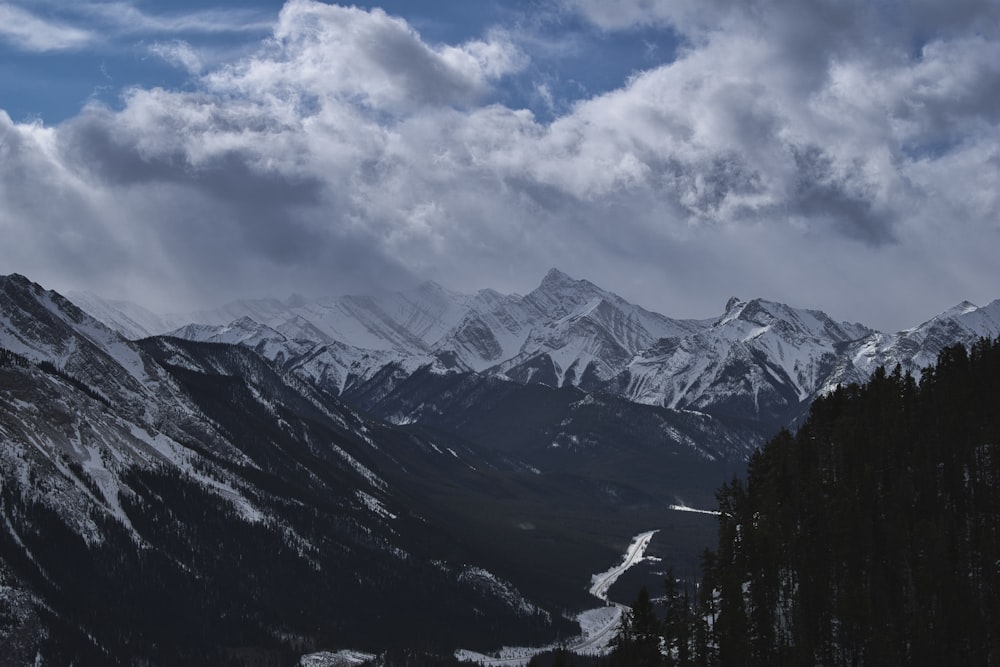 snow covered mountains under cloudy sky during daytime