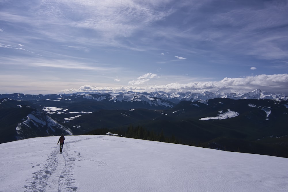 person walking on snow covered mountain during daytime