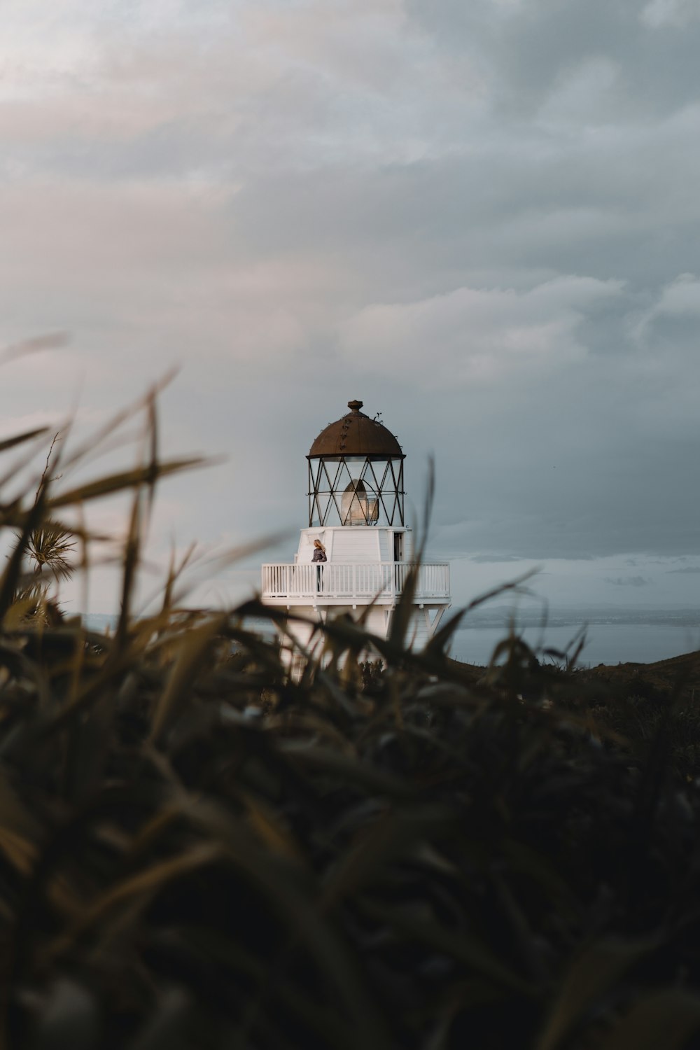 Phare blanc et noir sous un ciel nuageux pendant la journée