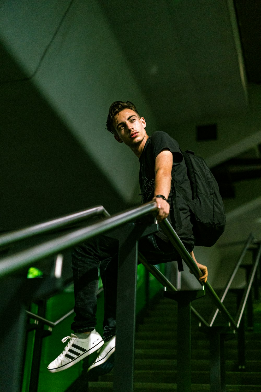 man in black t-shirt and black pants standing on stairs
