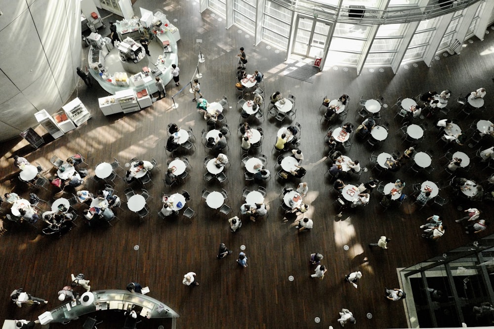 people in a building with a white and black tables and chairs