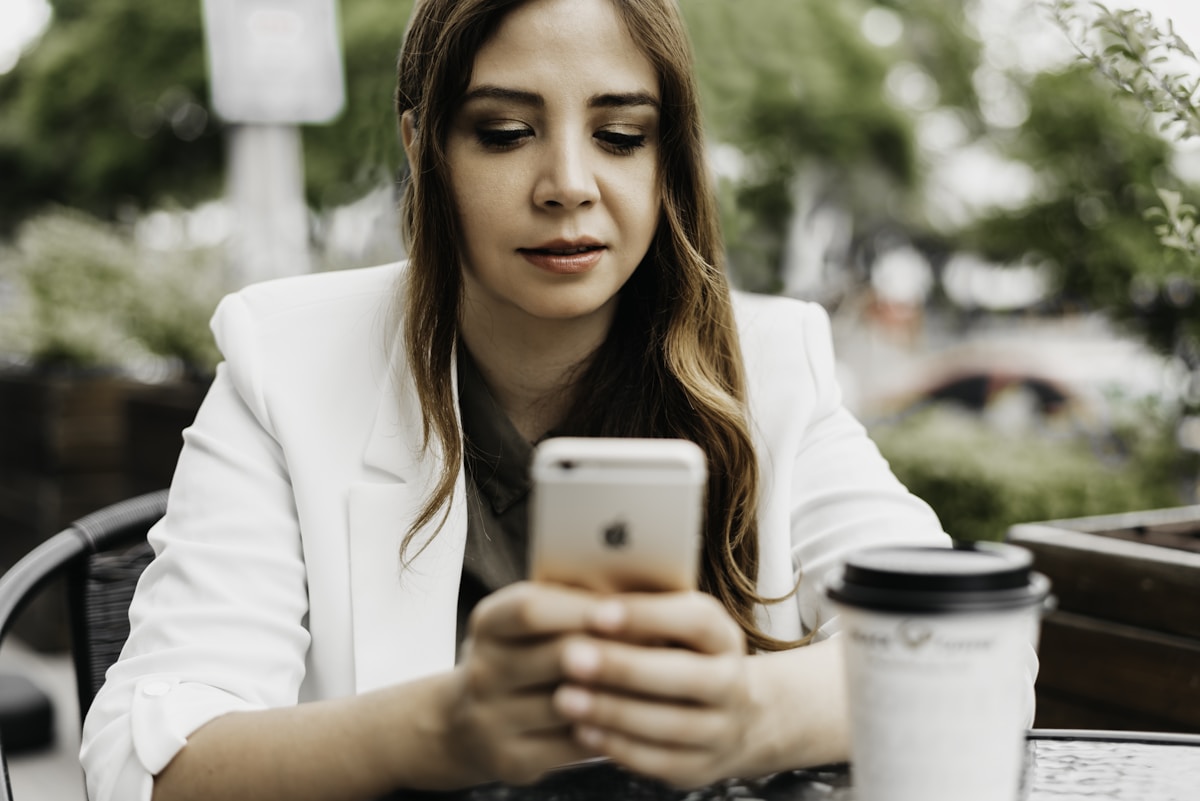 Dona de salão de beleza escolhendo um sistema de agendamento no celular