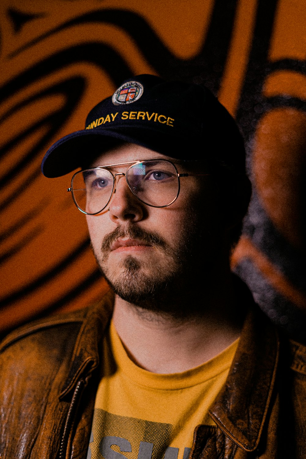 man in black framed eyeglasses and black cap