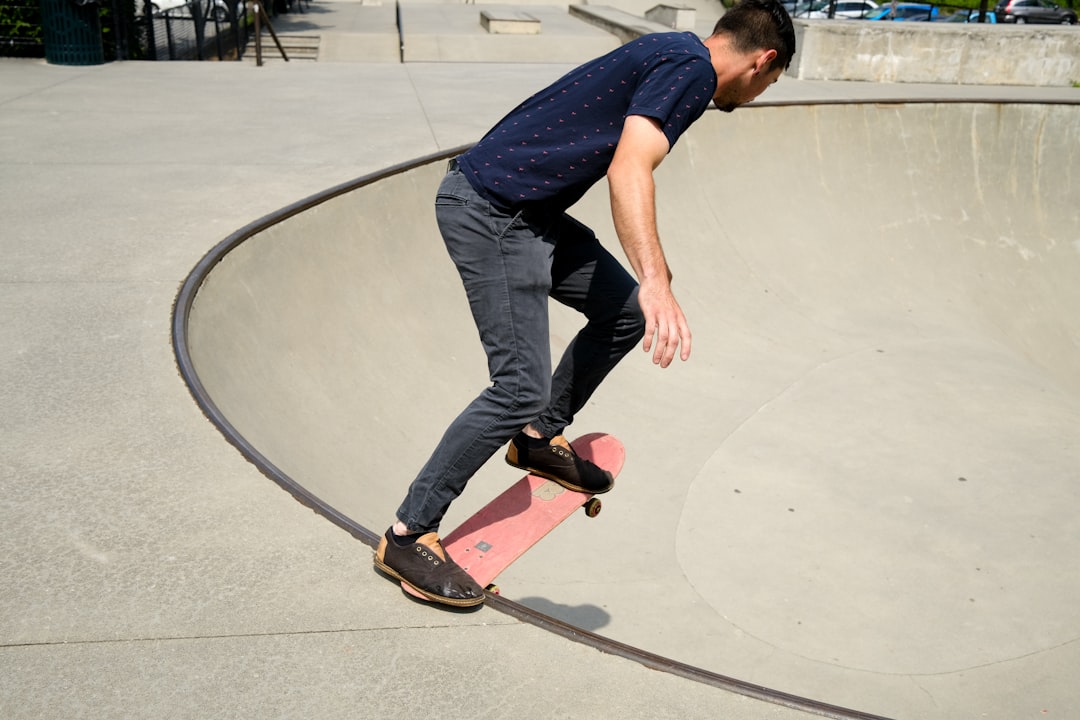 man in blue t-shirt and blue denim jeans riding skateboard during daytime