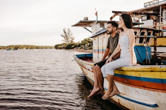 woman in white and blue striped dress sitting on white and blue boat during daytime