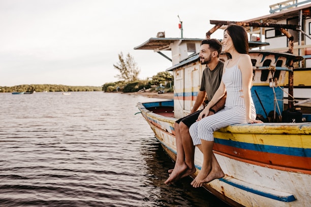 woman in white and blue striped dress sitting on white and blue boat during daytime