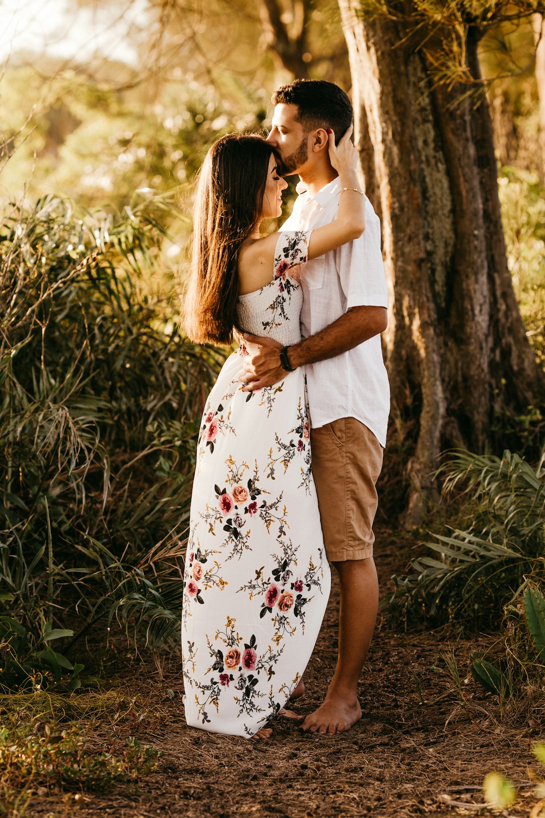 woman in white floral dress standing near tree