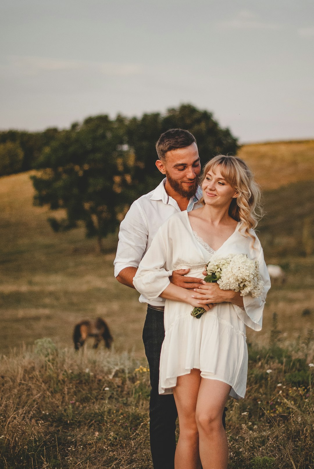 man in white dress shirt holding woman in white dress