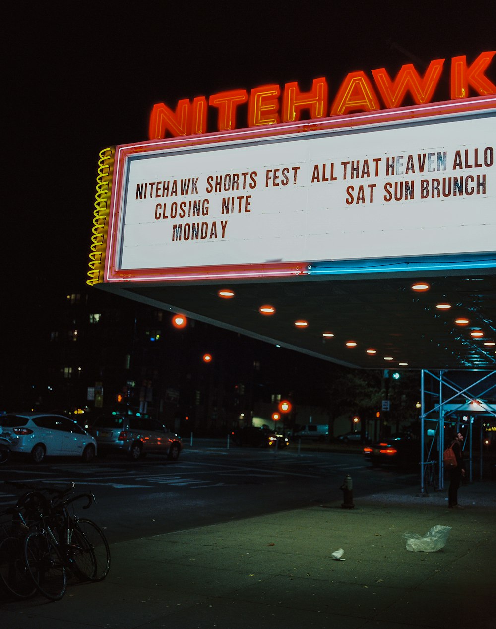 a lit up sign for a theater at night