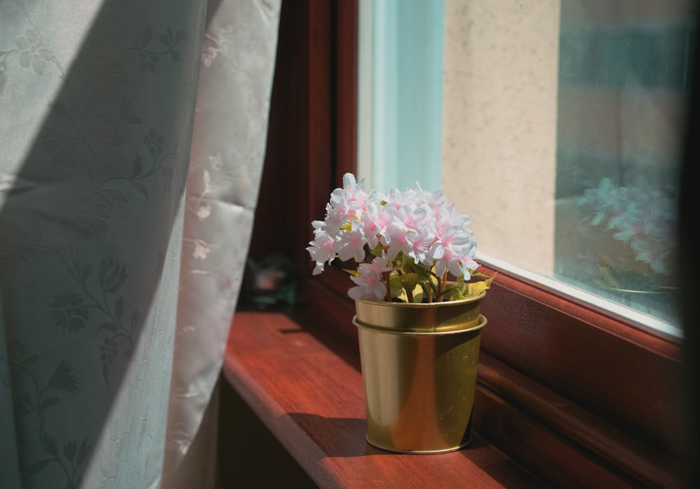 pink and white flowers in yellow pot on red table