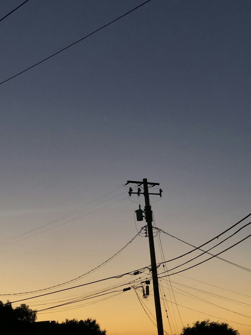 schwarzer Strommast unter blauem Himmel tagsüber