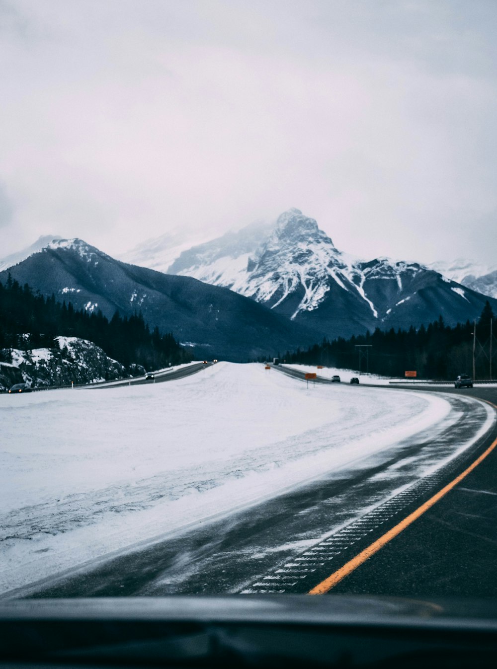 black asphalt road near snow covered mountain during daytime
