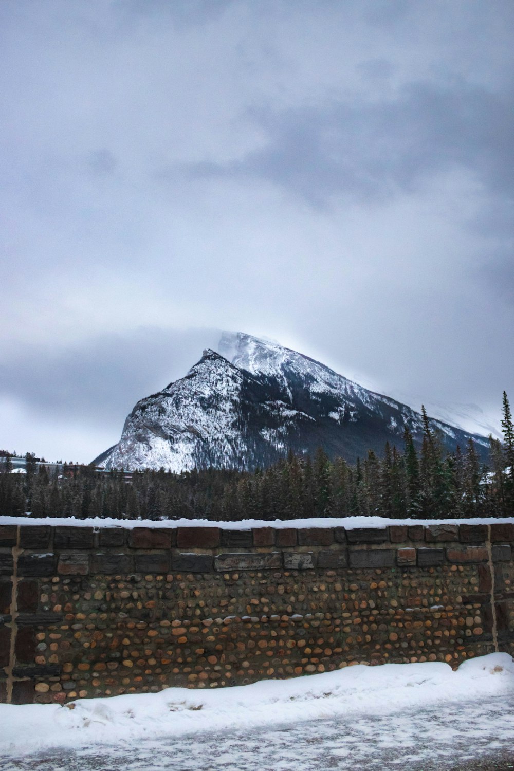 snow covered mountain under cloudy sky during daytime