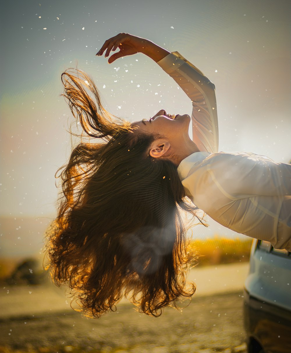 woman in white long sleeve shirt raising her hands