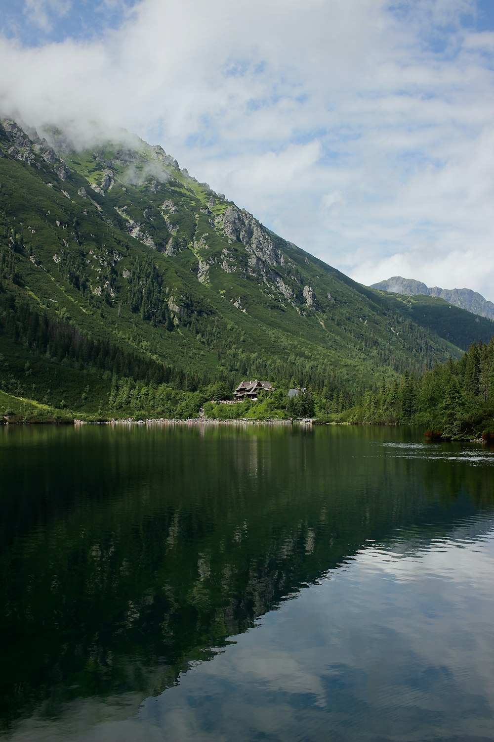 green mountains beside lake under blue sky during daytime