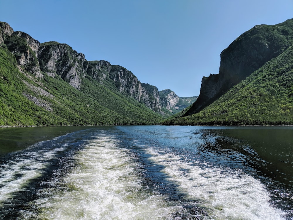 green and gray mountains beside river under blue sky during daytime