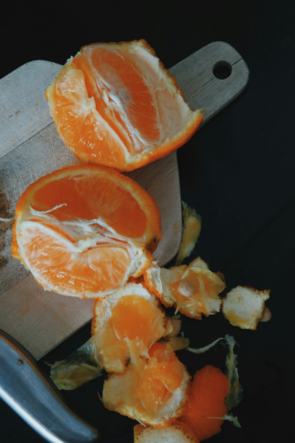 sliced orange fruit on brown wooden chopping board