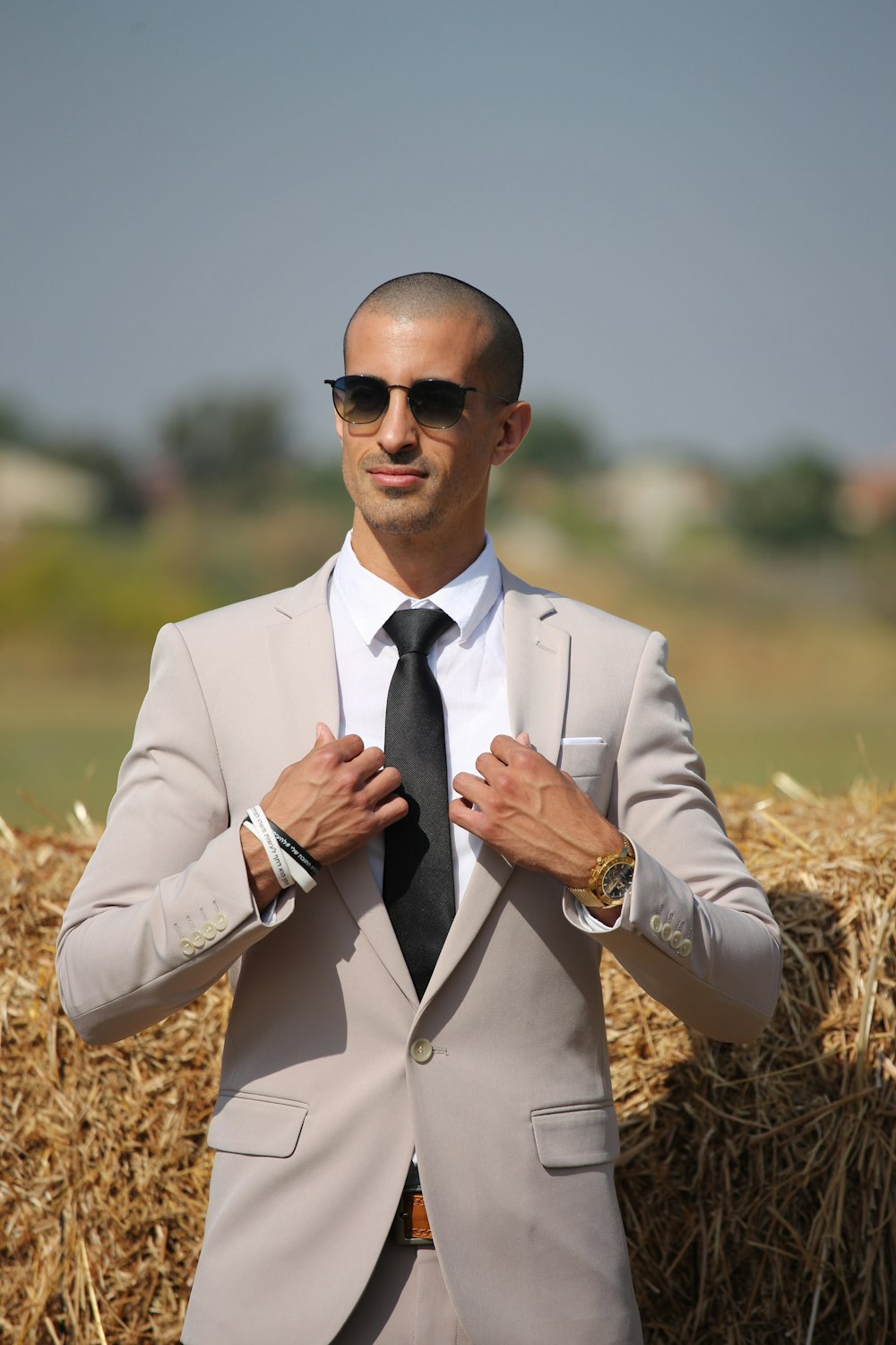 man in beige blazer wearing black sunglasses