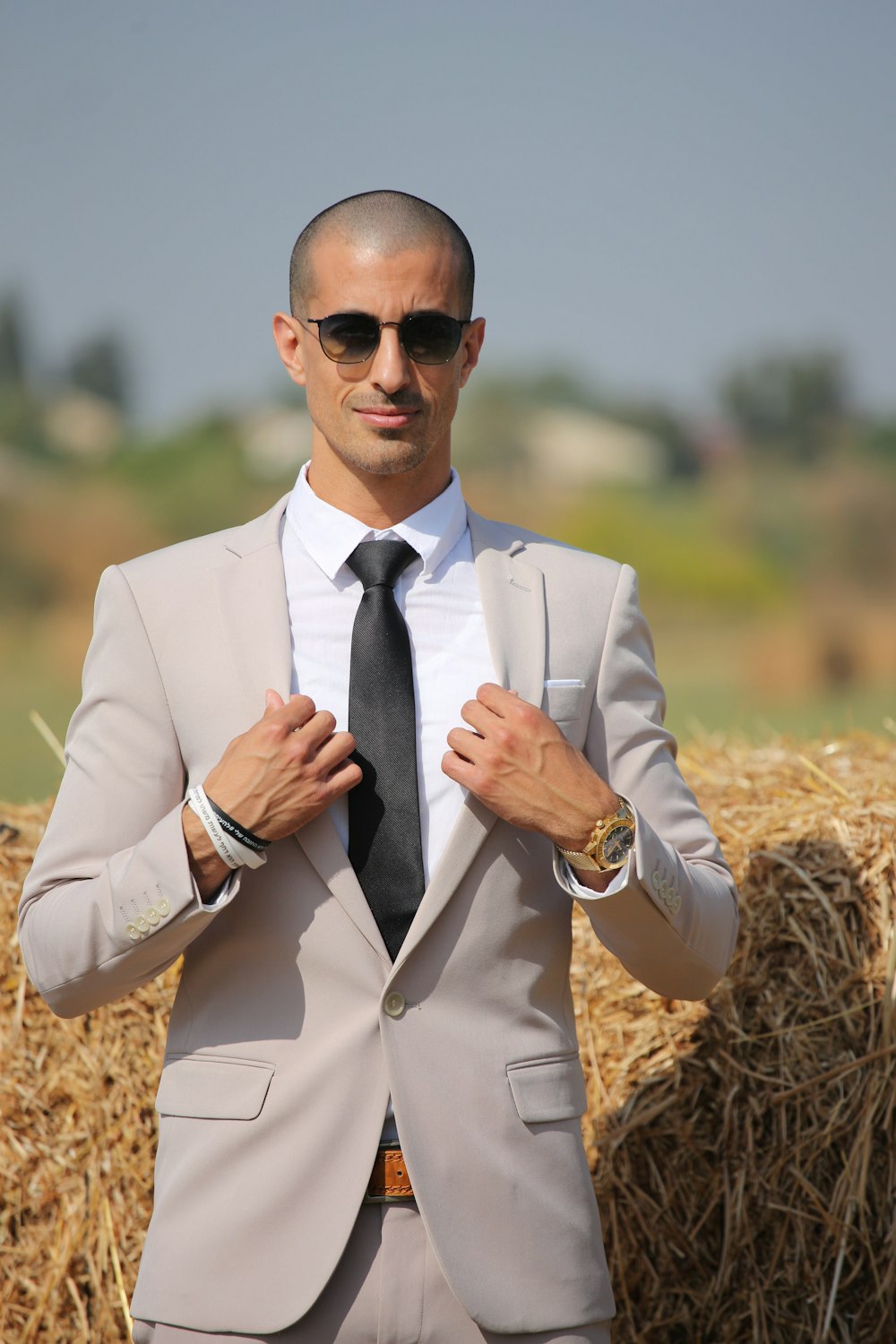 man in beige blazer wearing black sunglasses