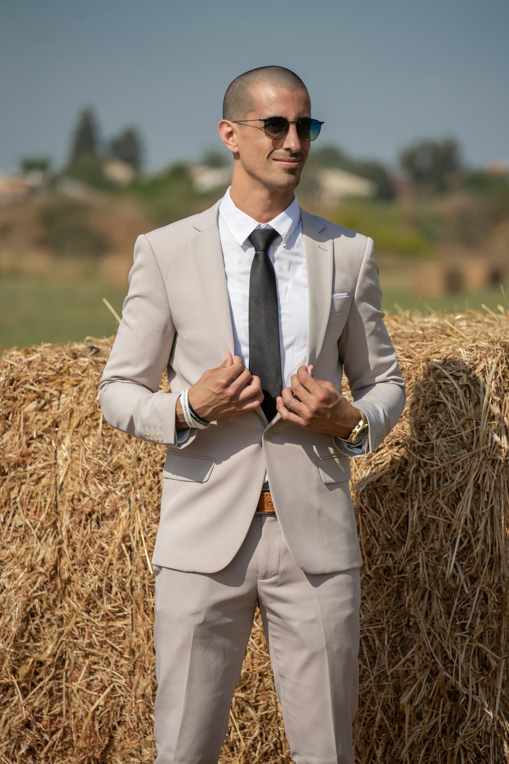 man in gray suit standing on brown grass field during daytime