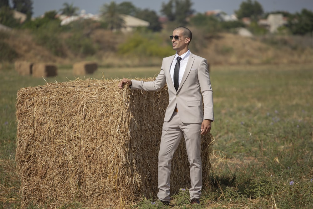 man in white suit standing on brown grass field during daytime