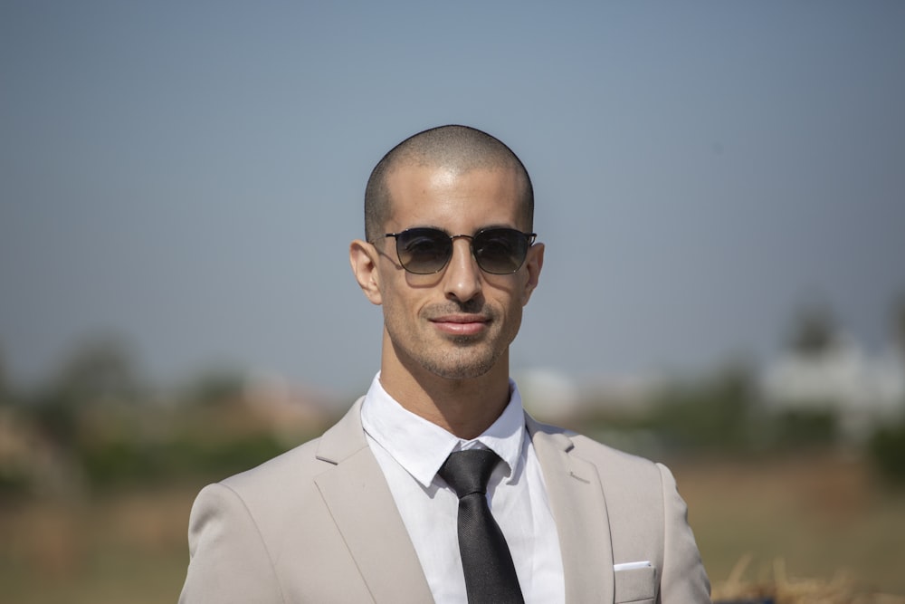 Hombre con traje blanco con gafas de sol negras