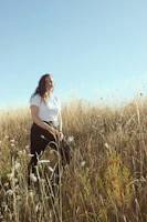 Portrait of a smiling woman standing confidently in a sunlit garden, symbolizing hope and recovery.