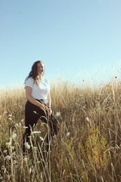A smiling woman taking a deep breath outdoors, feeling relief from asthma symptoms.