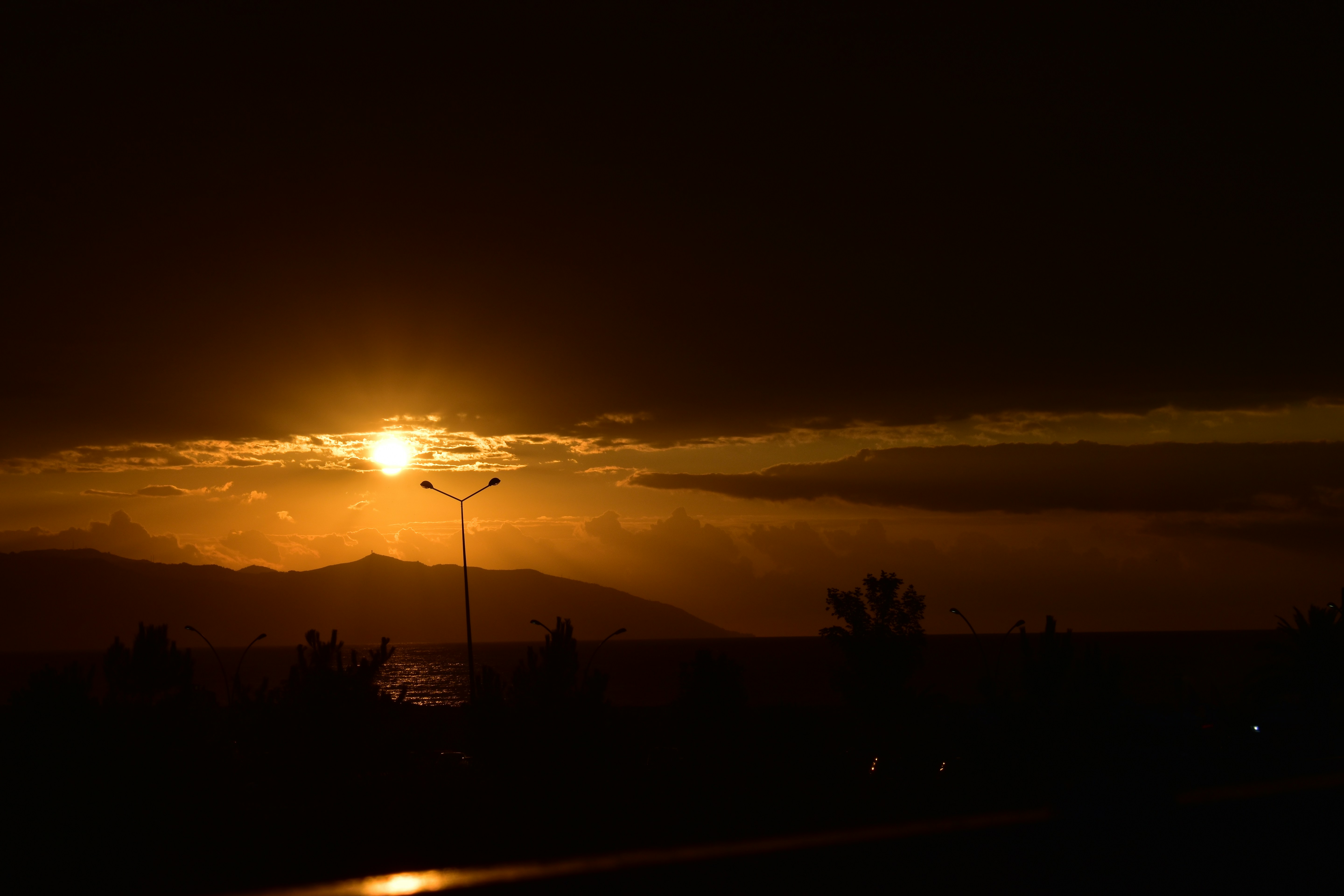 Golden sunset over mountain range with clouds