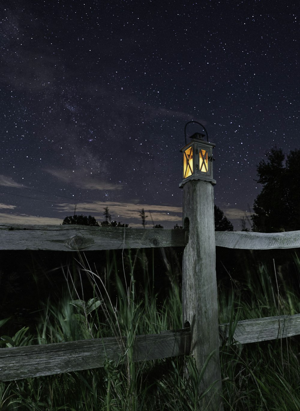 black and white lamp post near green grass during night time