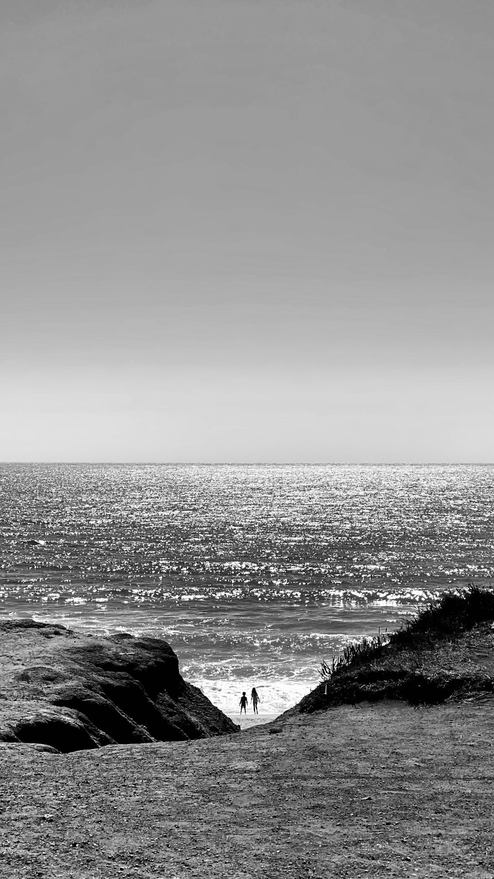 grayscale photo of ocean waves crashing on rocks