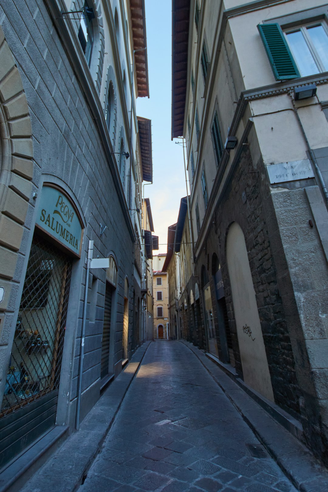 empty hallway between concrete buildings during daytime