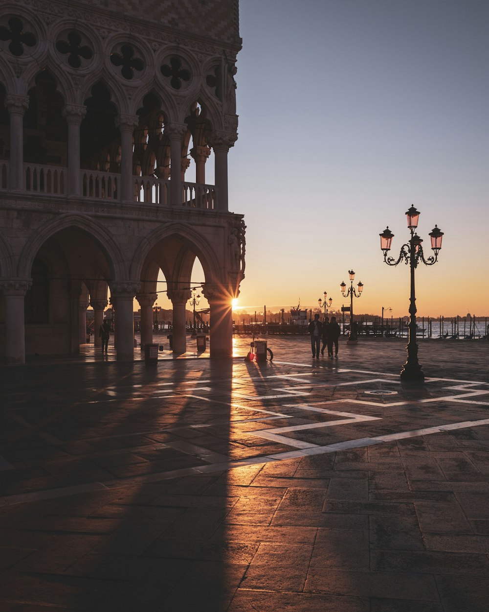 people walking on sidewalk during sunset