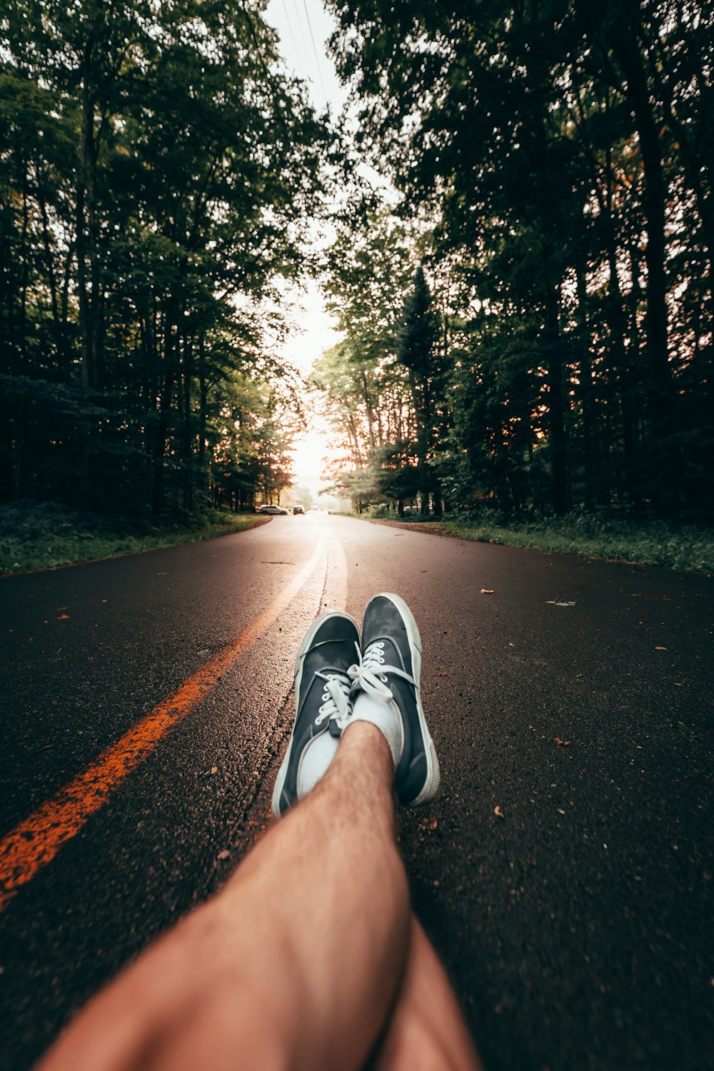 person in gray and white nike sneakers on gray asphalt road during daytime