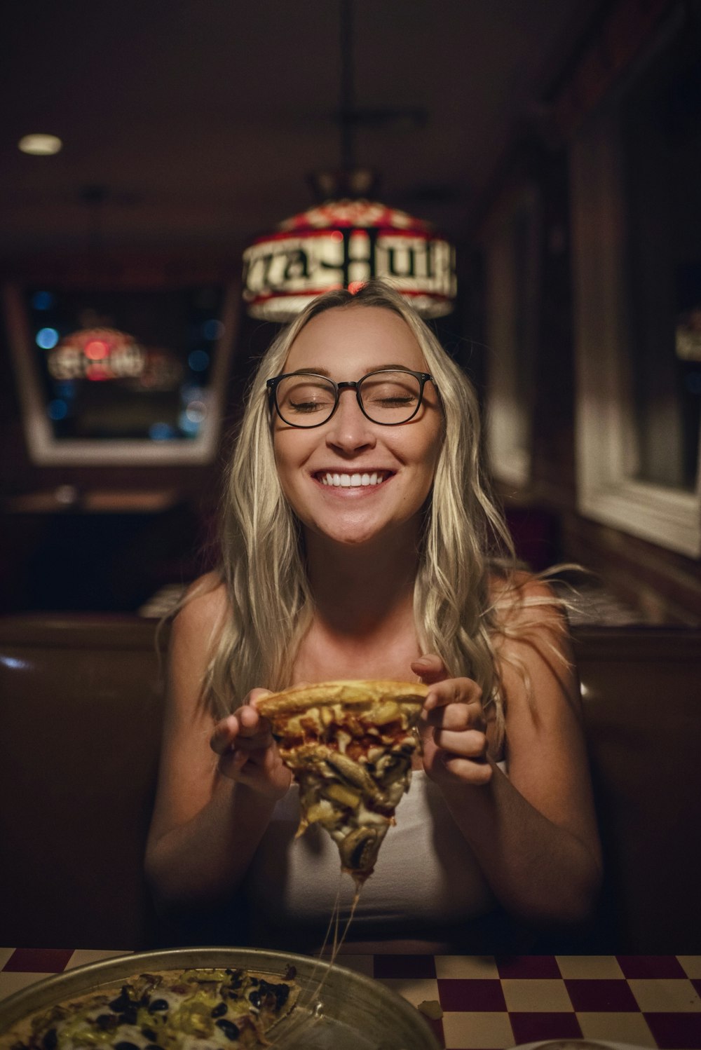 woman in black framed eyeglasses holding burger