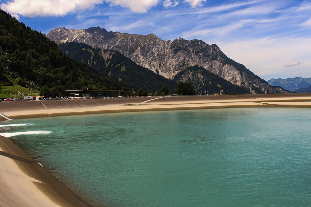 mare blu vicino alla montagna sotto il cielo blu durante il giorno