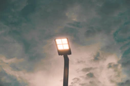 black and white lamp post under gray clouds