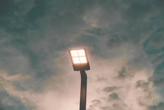 black and white lamp post under gray clouds