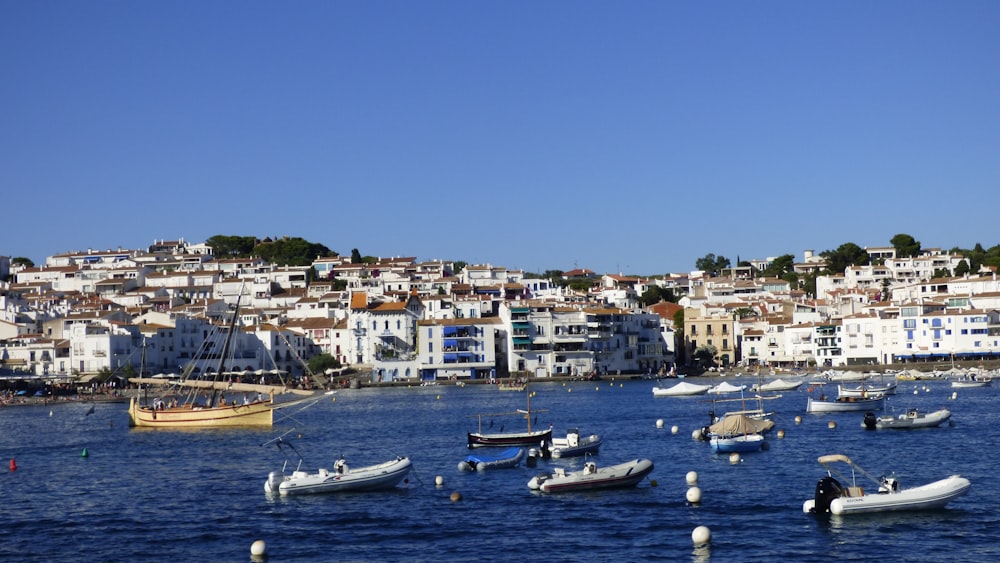 Barca bianca e blu sul mare vicino agli edifici della città durante il giorno