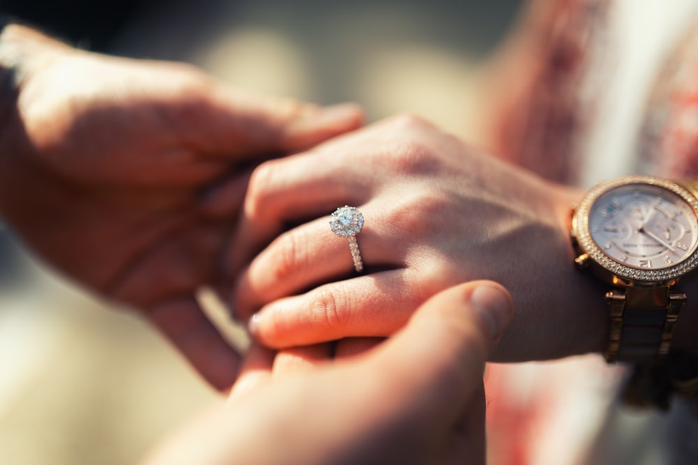 silver diamond ring on persons hand