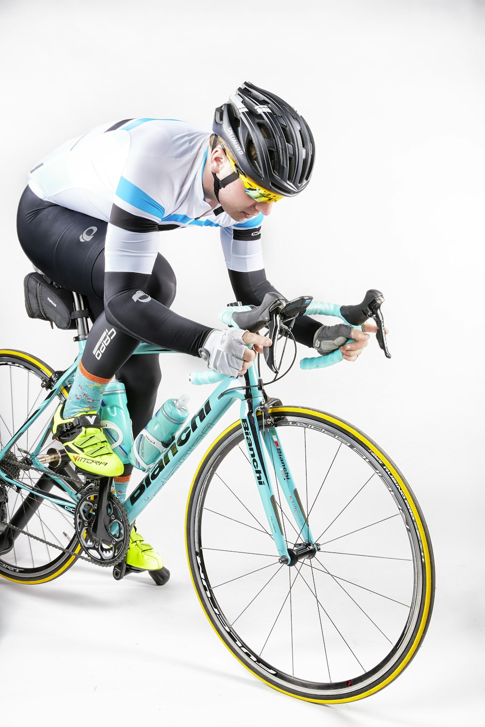 woman in white long sleeve shirt and black pants riding on blue and yellow bicycle