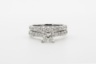 silver diamond studded ring on white surface