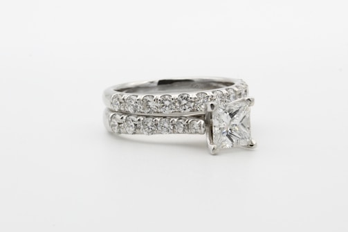 silver diamond ring on white surface